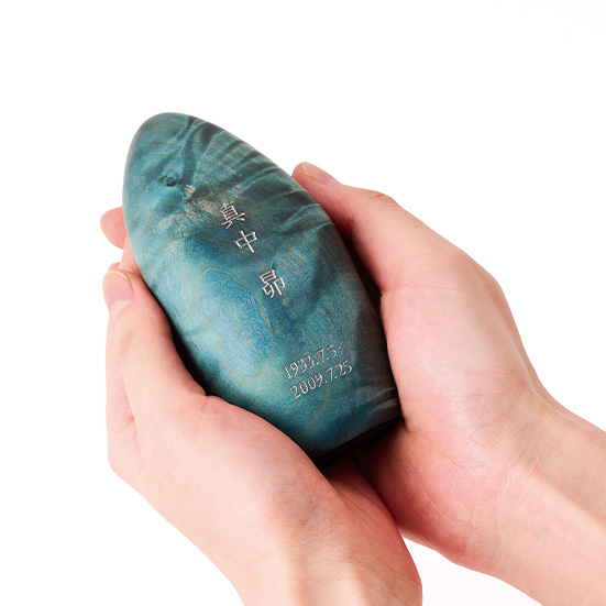 お位牌「星牌 木」湧水（青）を手で包み込む様子